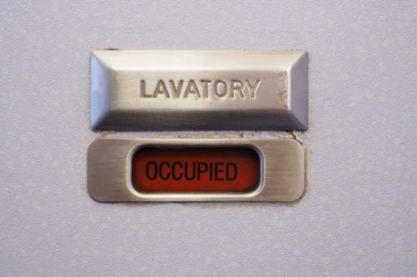 Close up pilot hand taking by portable radio set in cabin while navigating plane. Occupation and communication concept