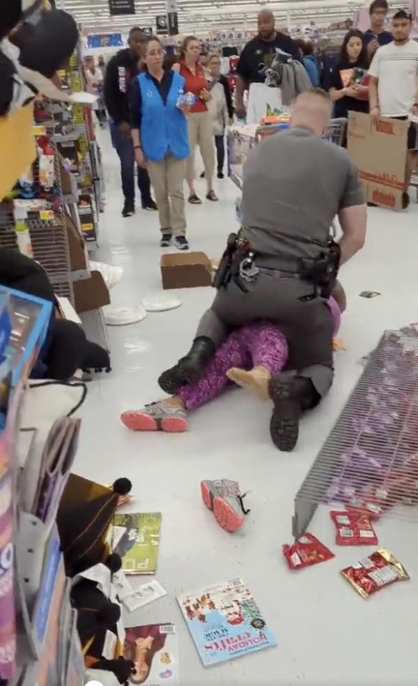 The cop is seen sitting on the woman. 