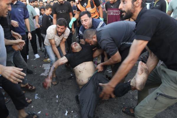 An injured Palestinian man is carried from the ground following an Israeli airstrike outside the entrance of the al-Shifa hospital in Gaza City, Friday, Nov. 3, 2023. (AP Photo/Abed Khaled)