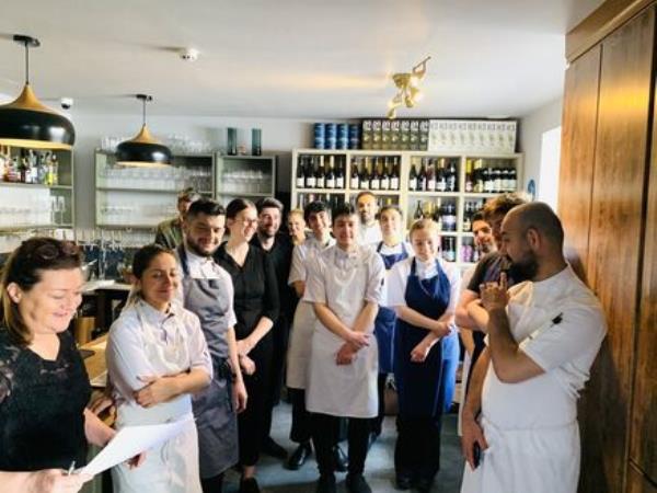 Ahmet Dede speaks with his kitchen staff at Customs House, Baltimore