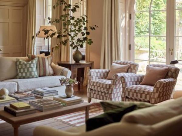 The curtains here are beautifully swept back from the reveal with the seating pulled close to the garden. Furnishings and paint colour (Potter Pink) by Neptune.