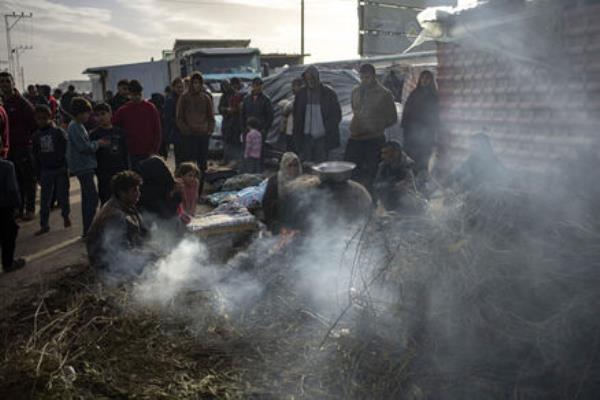 Palestinians displaced by the Israeli bombardment wait for their turn to bake bread at a makeshift tent camp in the Muwasi area in Rafah, Gaza Strip, 